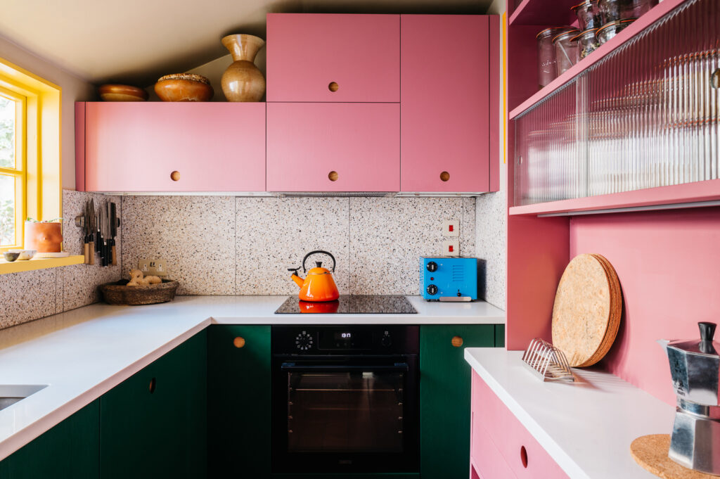 A picture of a green and pink kitchen.