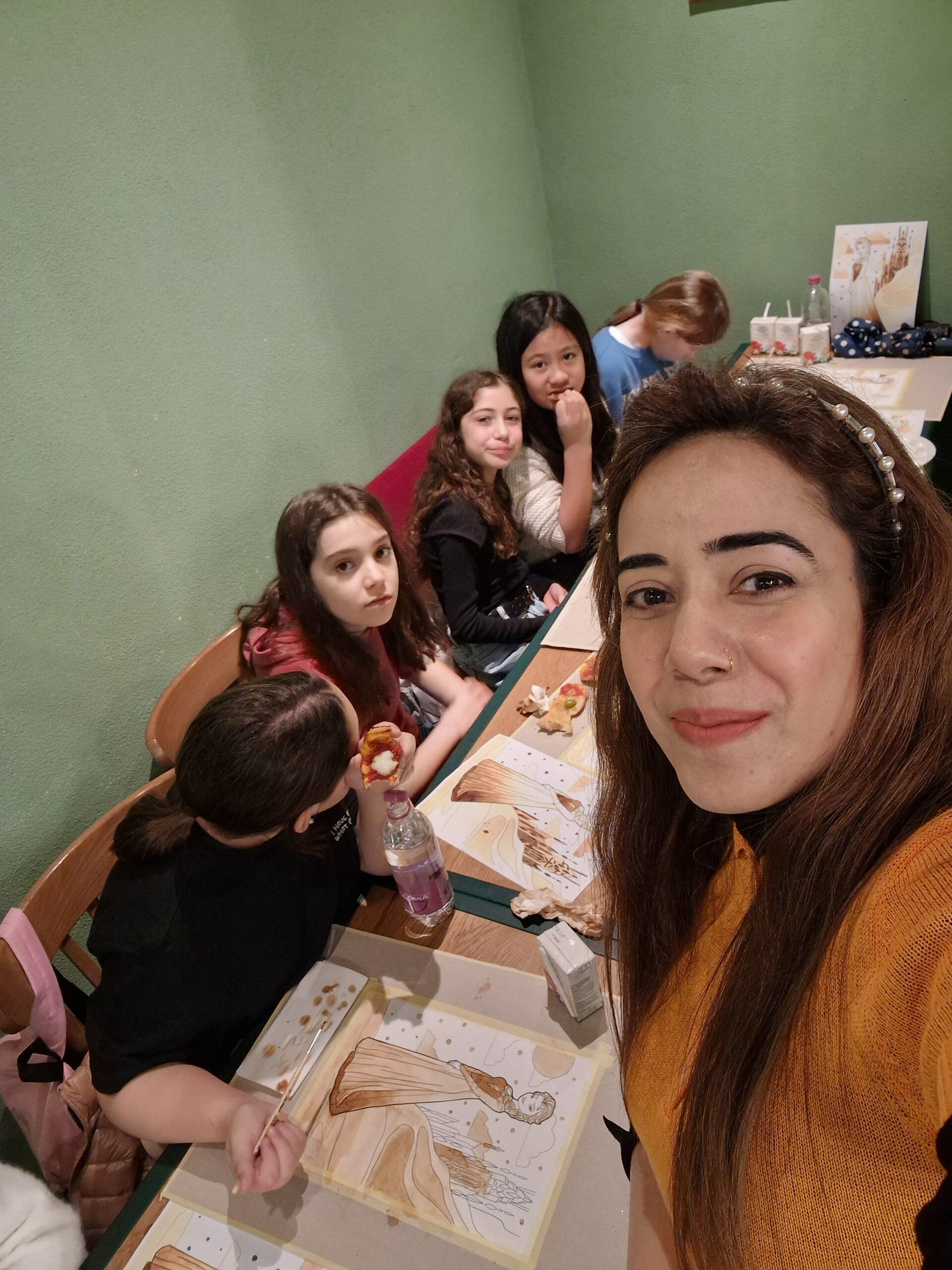 A picture of kids painting with instructor.
