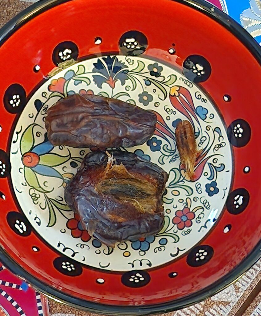 Picture of a Turkish red bowl with two Medjool dates.