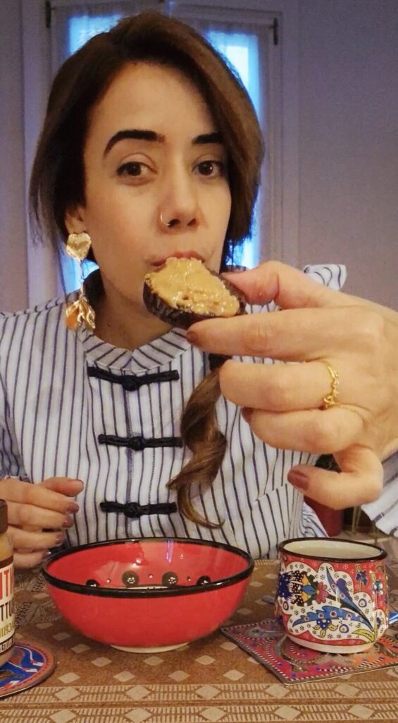 Picture of a girl showing a date filled with peanut butter.