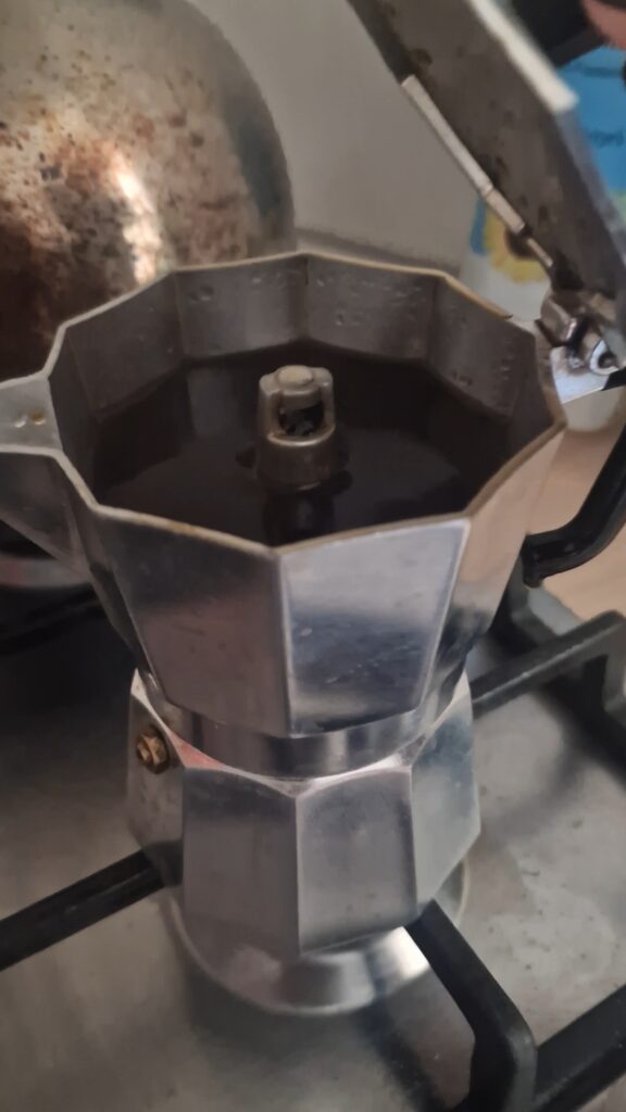 Picture of a moka pot filled with freshly brewed coffee. 
