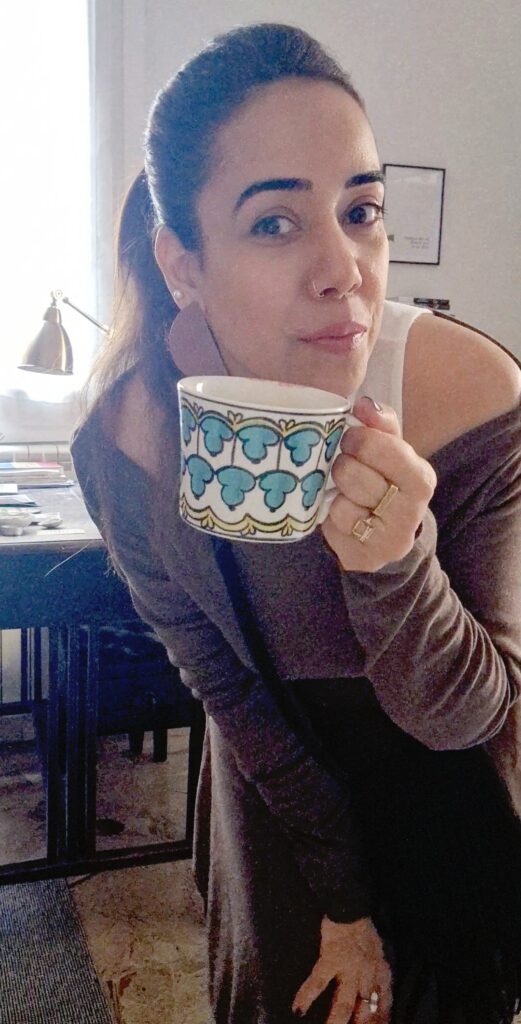Picture of a girl flaunting a white patterned coffee mug. 