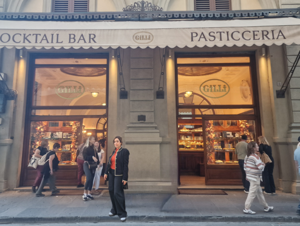A woman standing in front of a cafe in Florence.