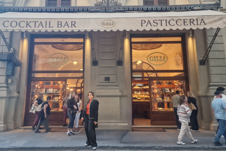 A woman standing in front of a cafe in Florence.